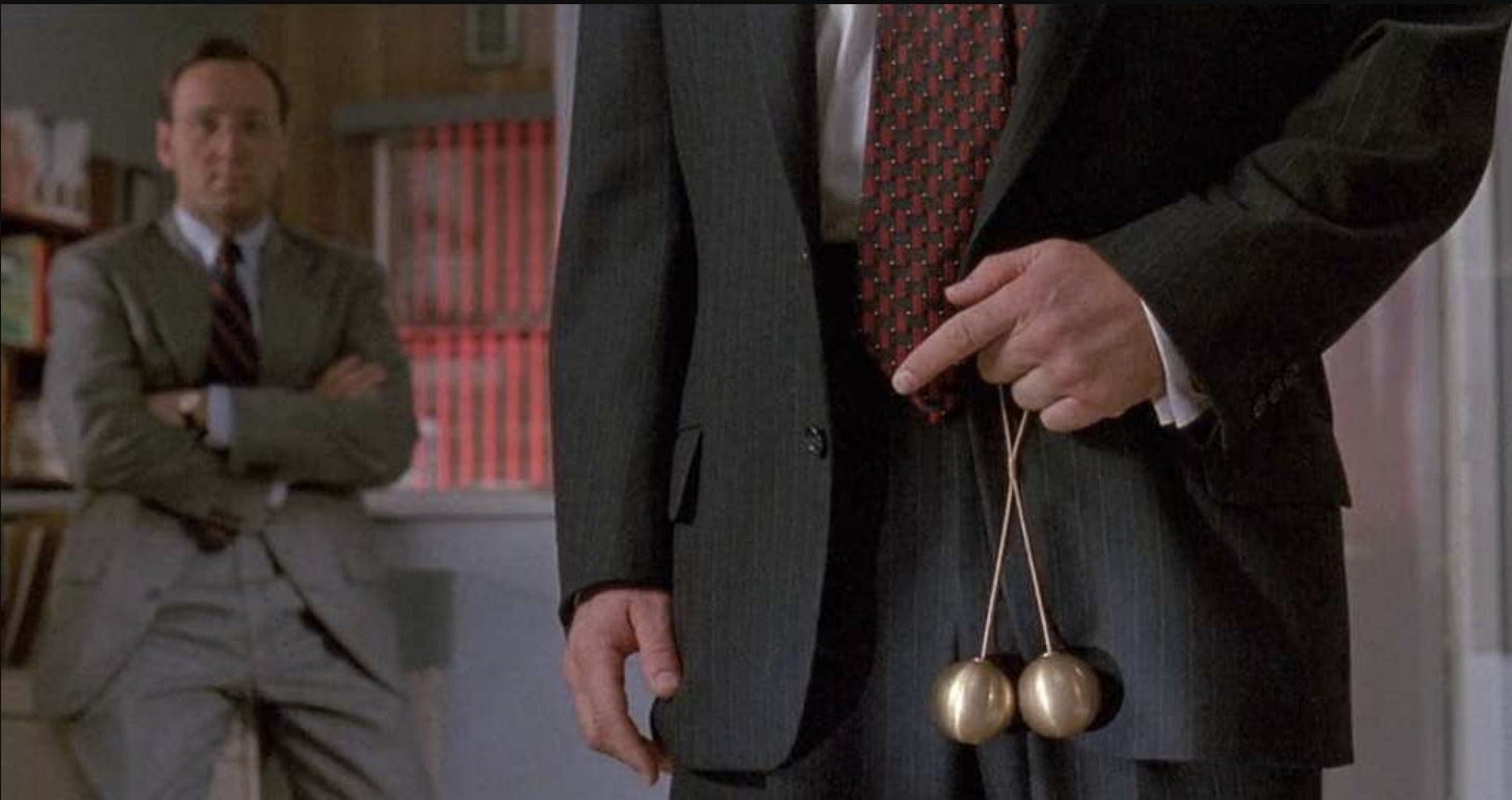 Scene from the movie Glengarry Ross — Alec Balding holding brass balls in front of his pants.