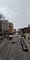 A red bus and several cars travel down a street under Pitt’s skybridge