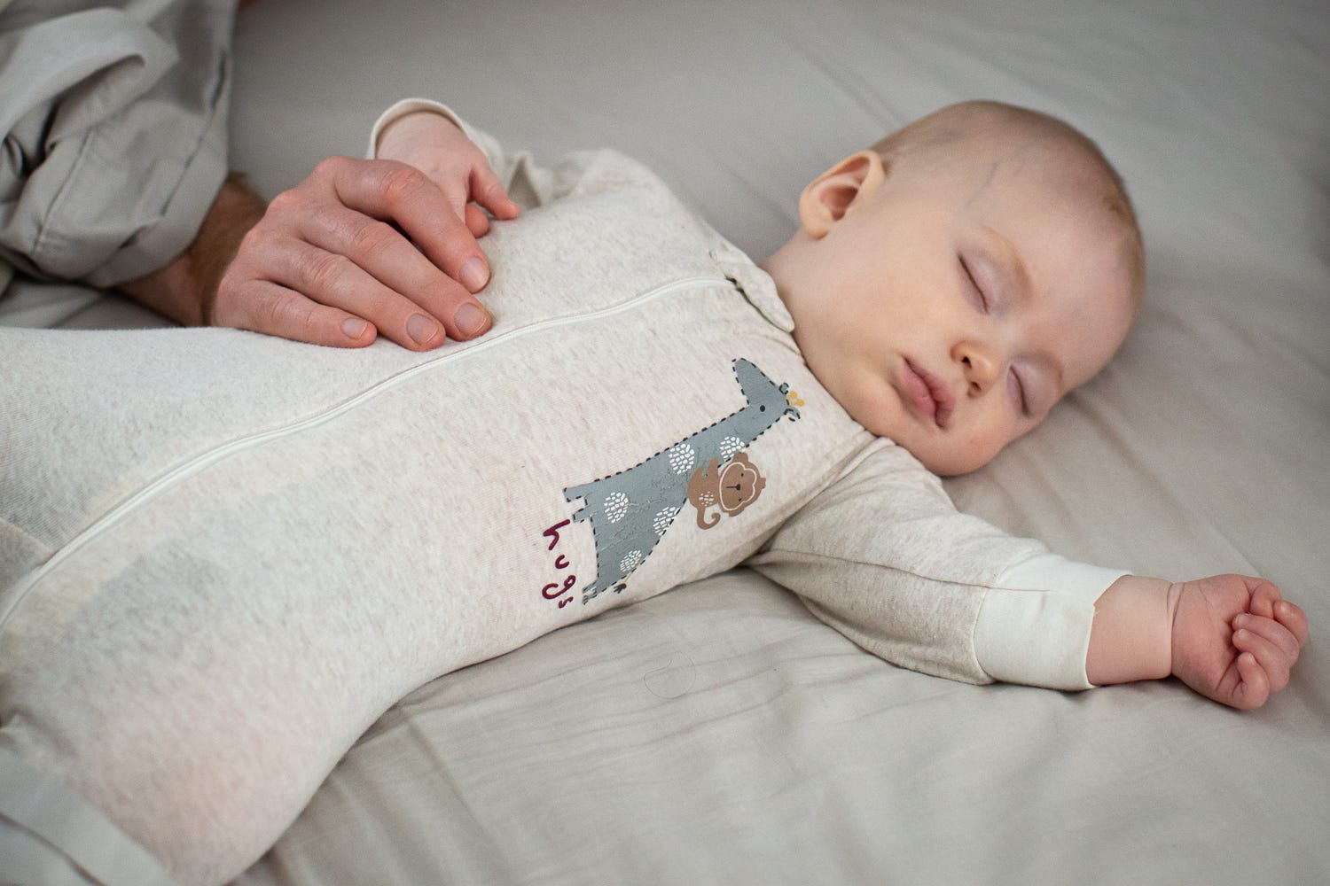 dad holding hands with sleeping baby