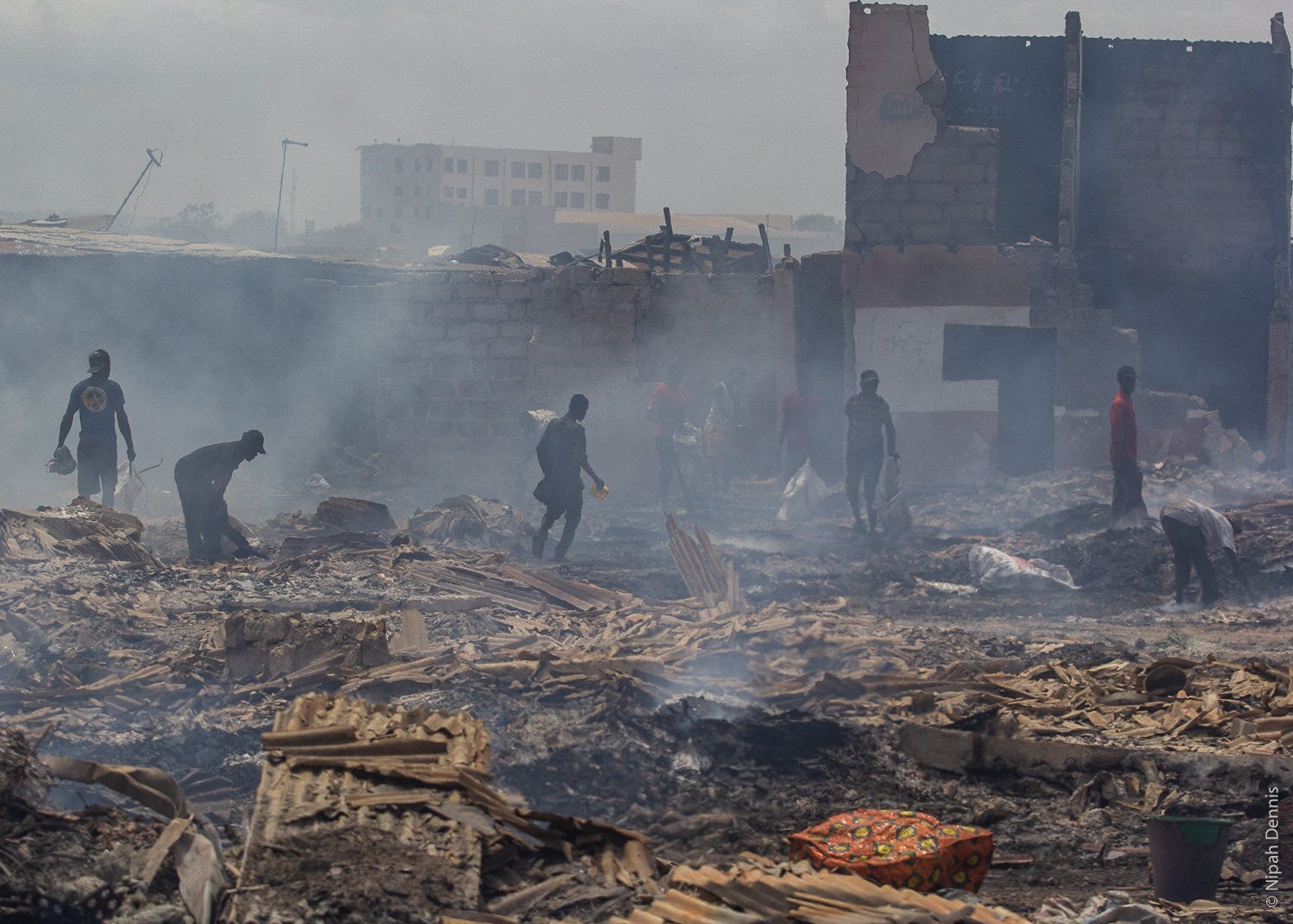 Residents try to find valuables in the debris after homes burn to the ground in Agbogbloshie, Accra, Ghana. April 7, 2020. Ph