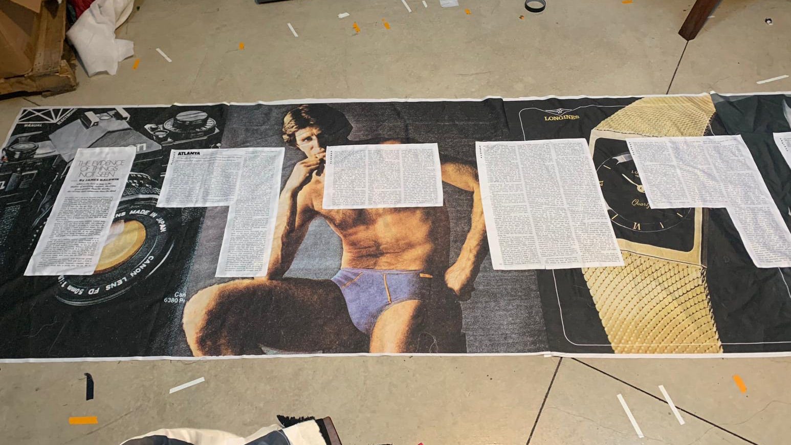 Fabric printed with texts laid over images of advertisements for men’s underwear, cameras, and watches.
