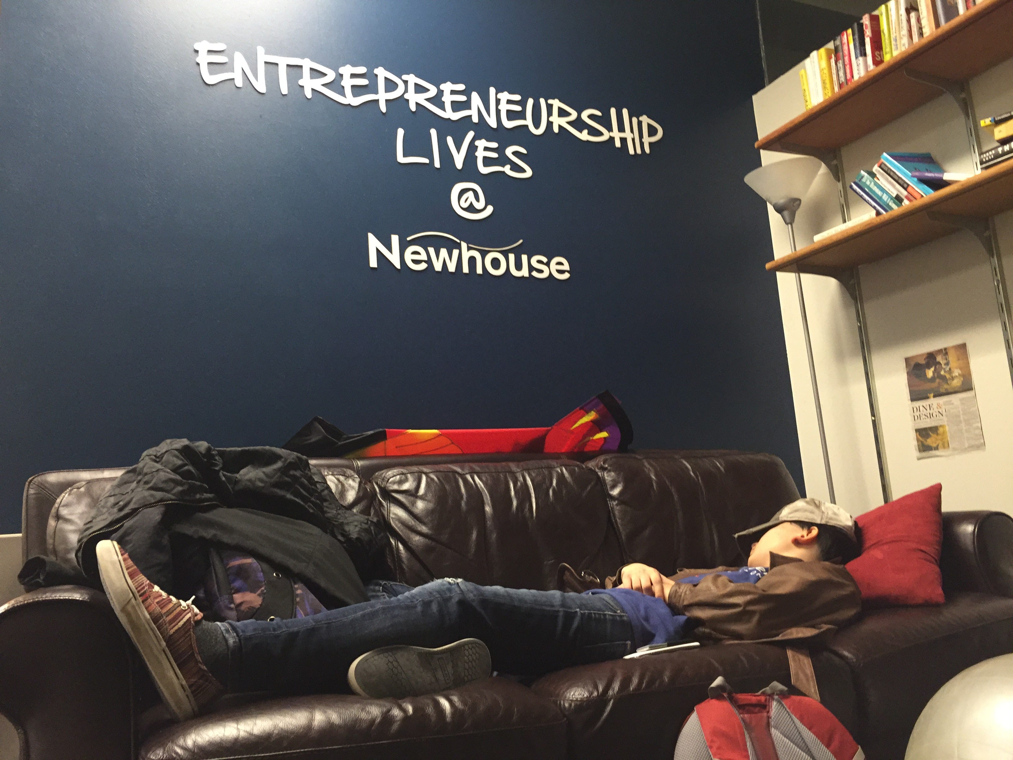 Student sleeping on a couch in the Newhouse school