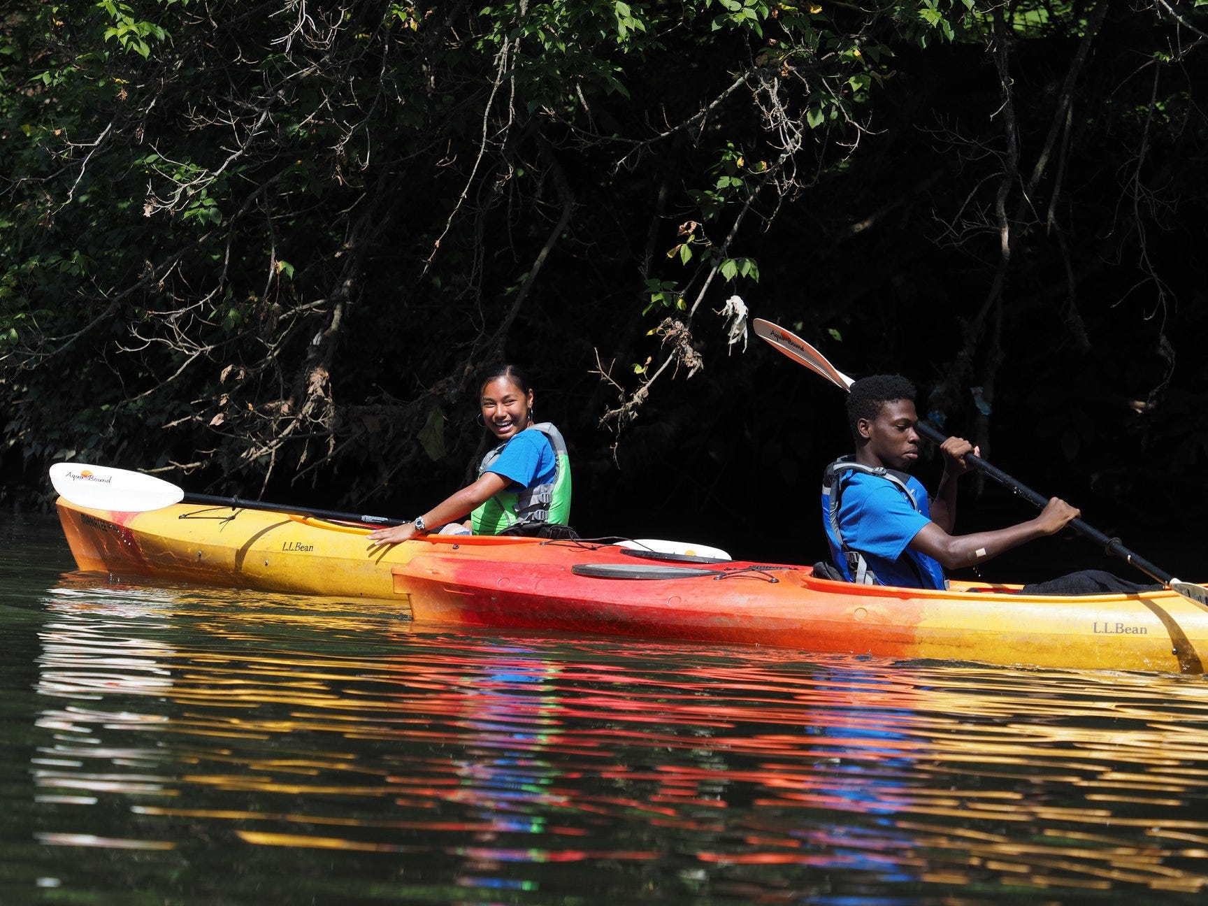 2 Kayakers near tree-filled shore