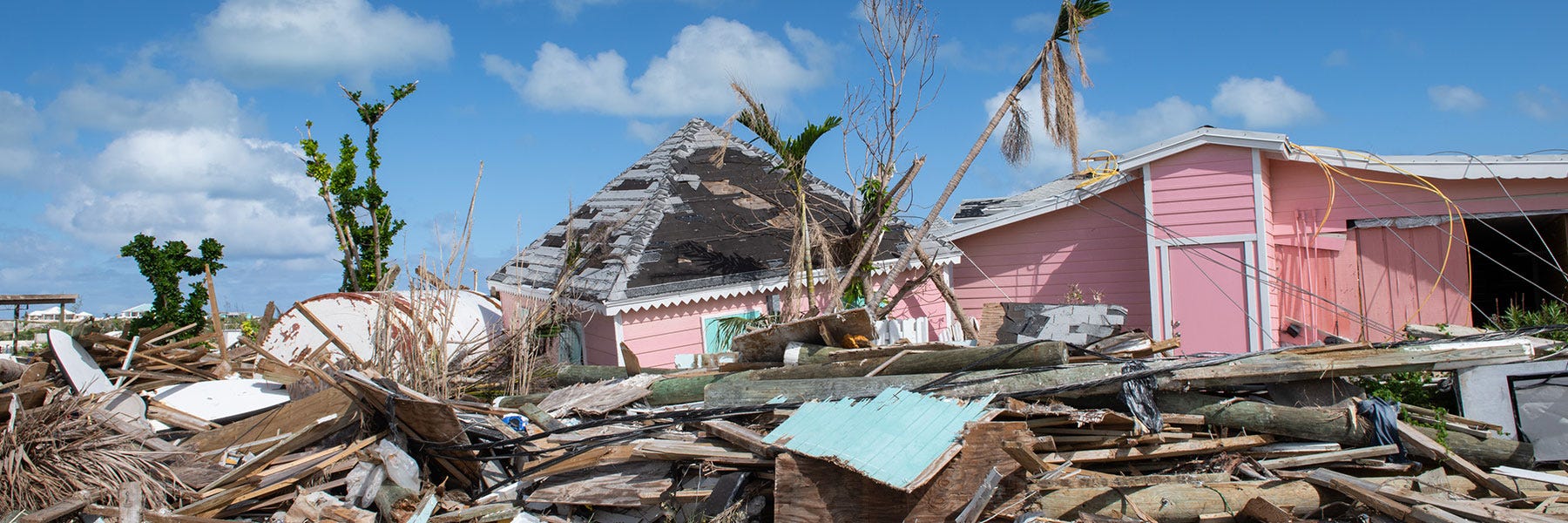 In The Bahamas a pink house and a pile of construction rubble stands in ruin after being hit by hurricane Dorian.