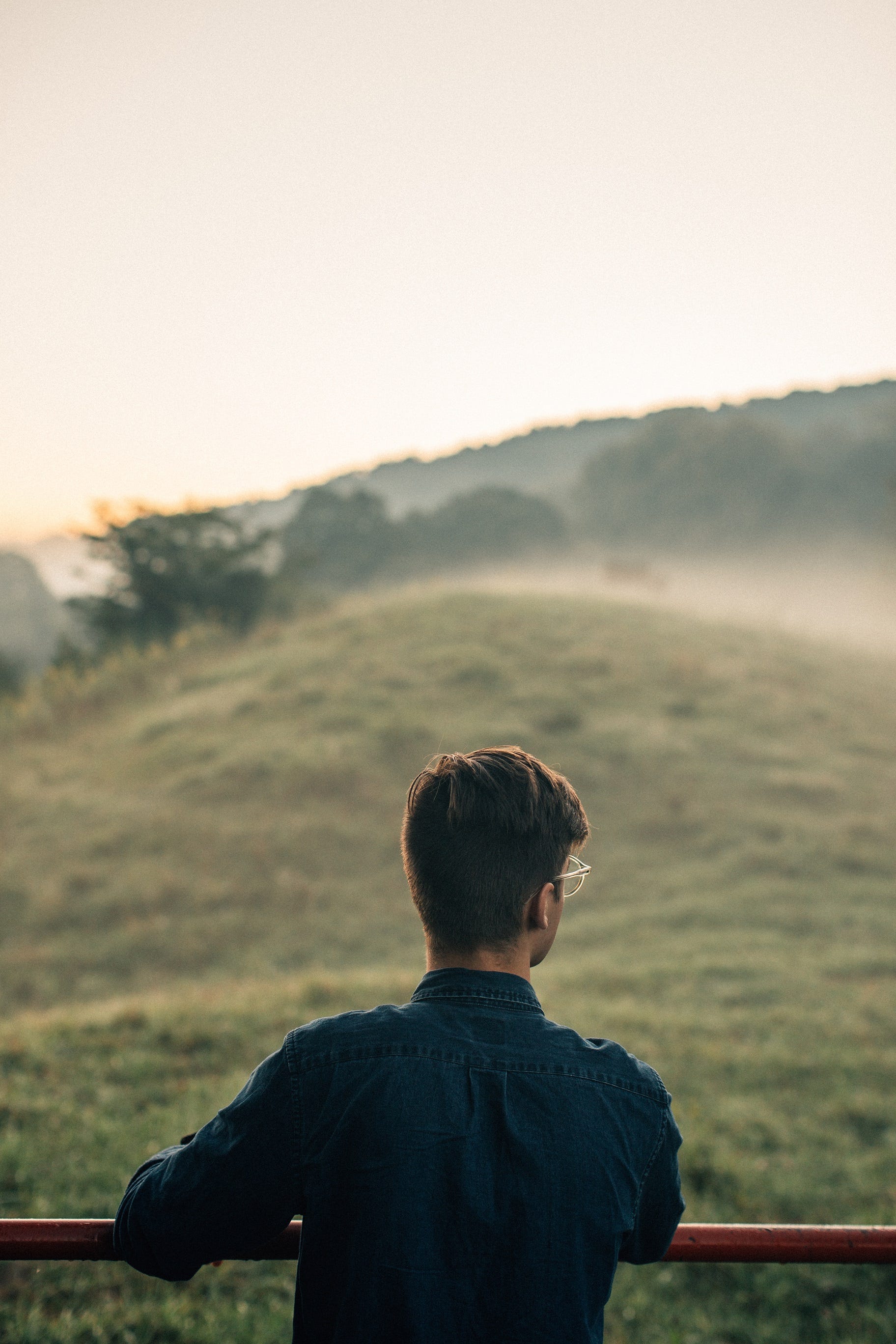 Man looking at a foggy hill.