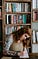 a young woman writing in a library