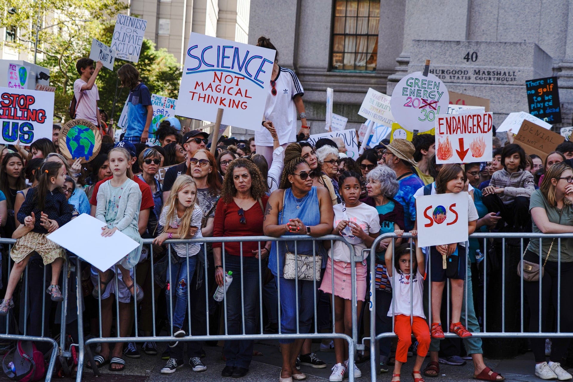 a photo of people at a climate change protest, including many children and young adults.