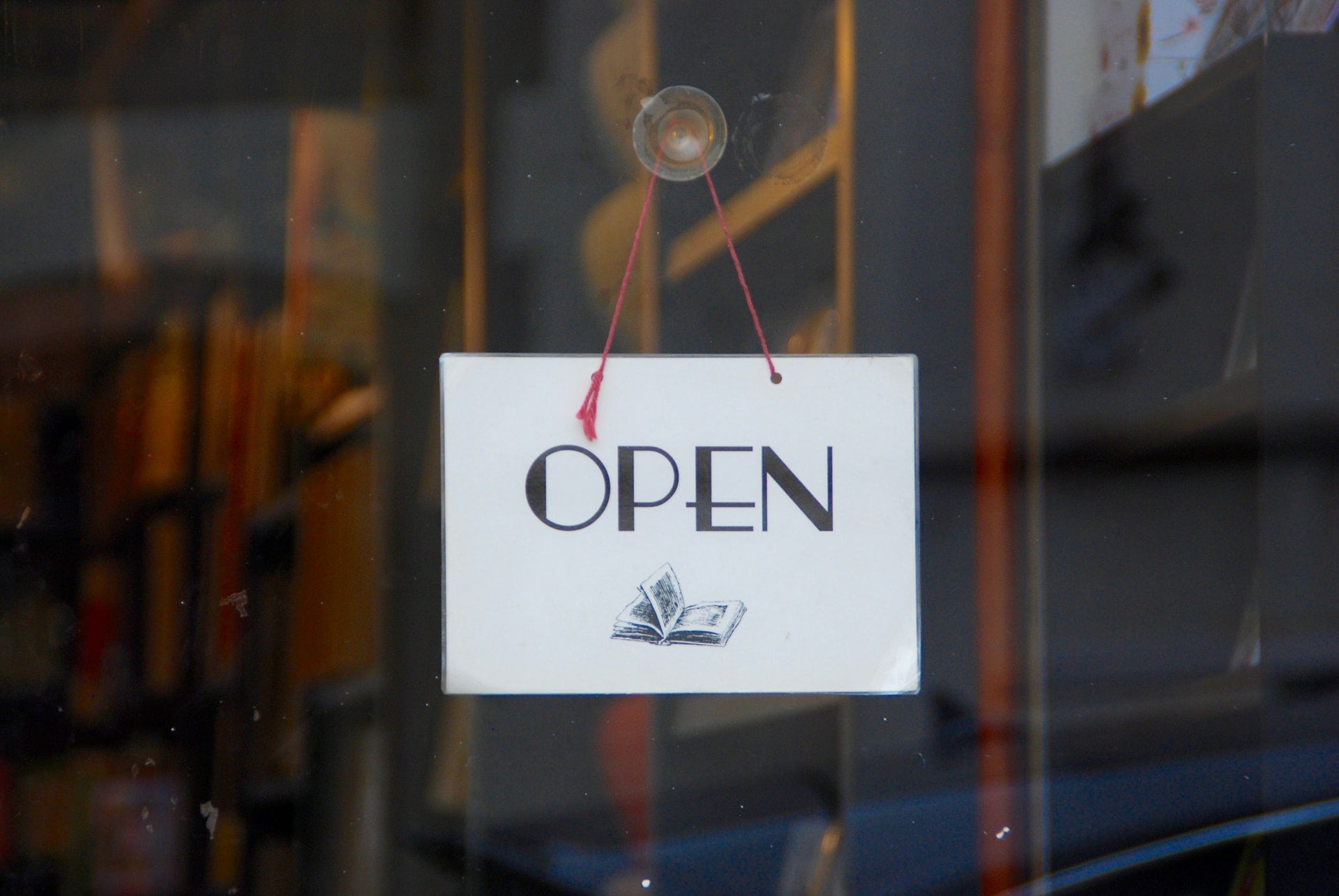 A sign on the door signifying the store as open to customers.