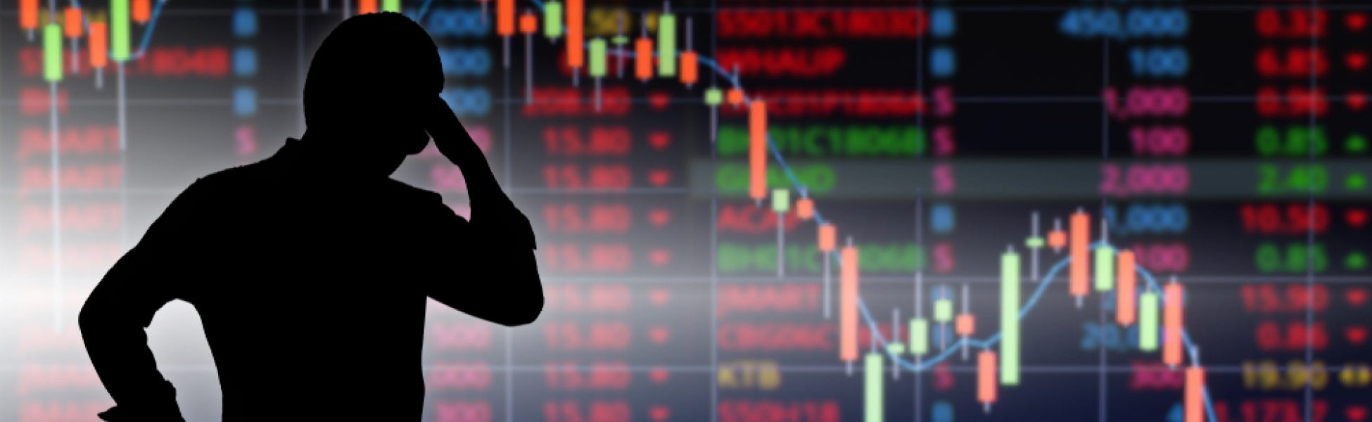 A Wall Street trader looks at a monitor showing the stock market index going down because of the coronavirus pandemic