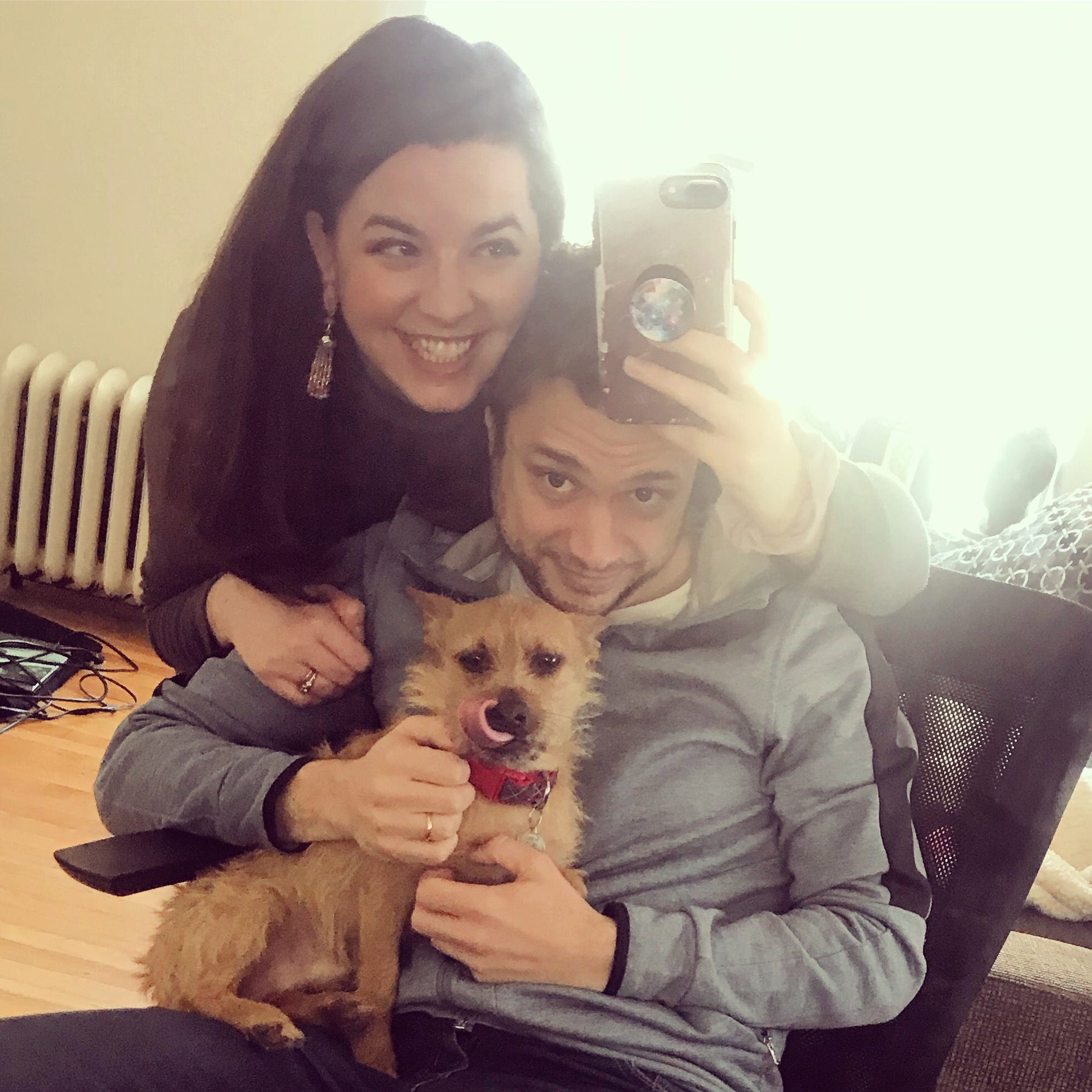 Megan, Tim and Arthur pose for a photo together; Arthur’s tongue is out licking his nose.
