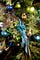 A blue bird ornament on a decorated fir tree.