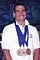 Gregory Burns is beaming with his paralympics swimming medals around his neck in 1996.