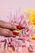 Red nails on a pink flower