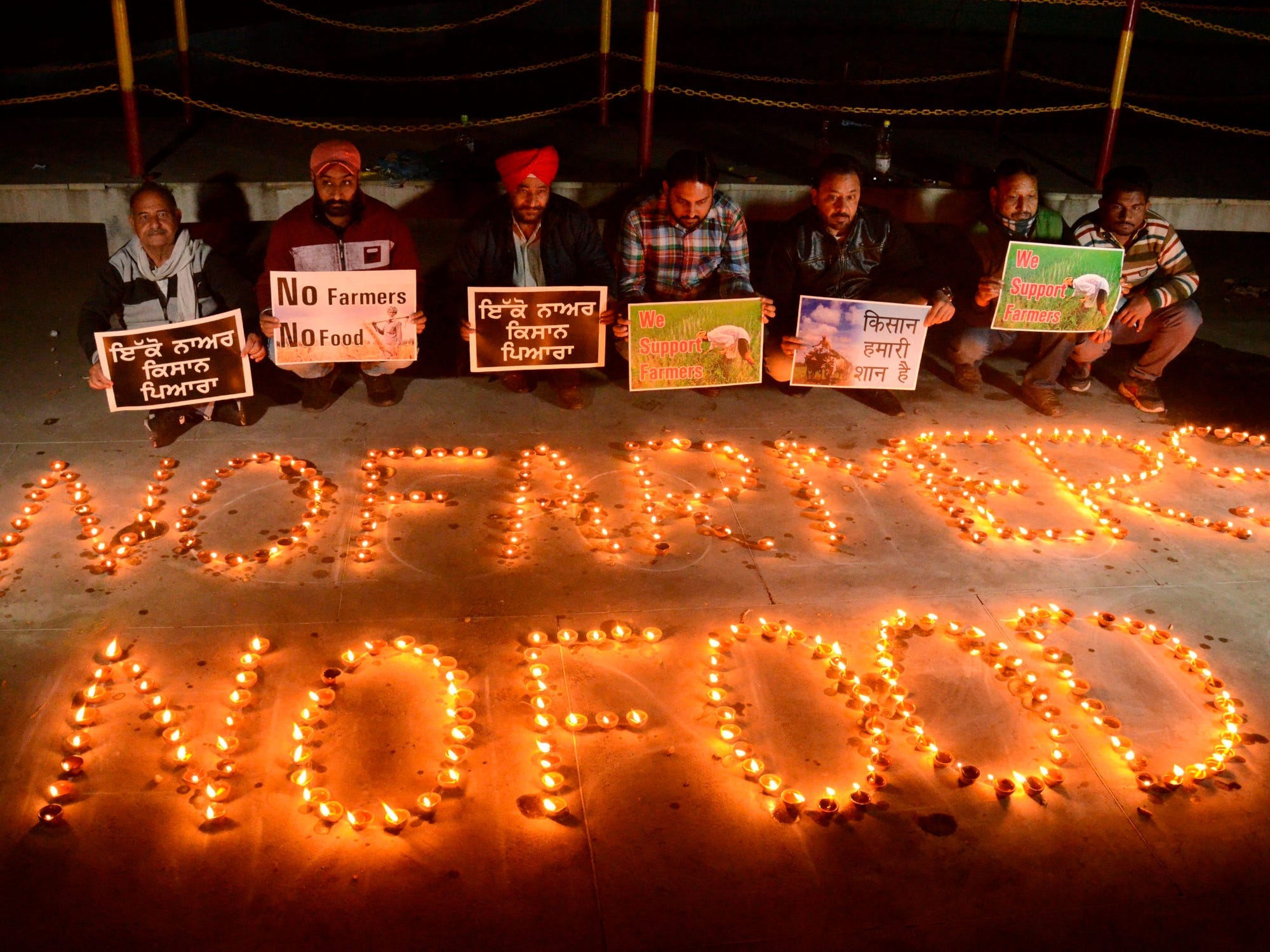 Members of human rights organizations hold placards in support of farmers during a protest.