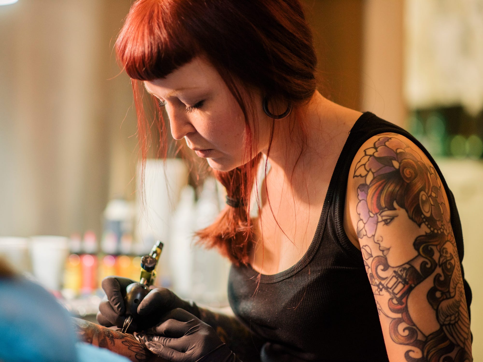 A tattoo artist working.