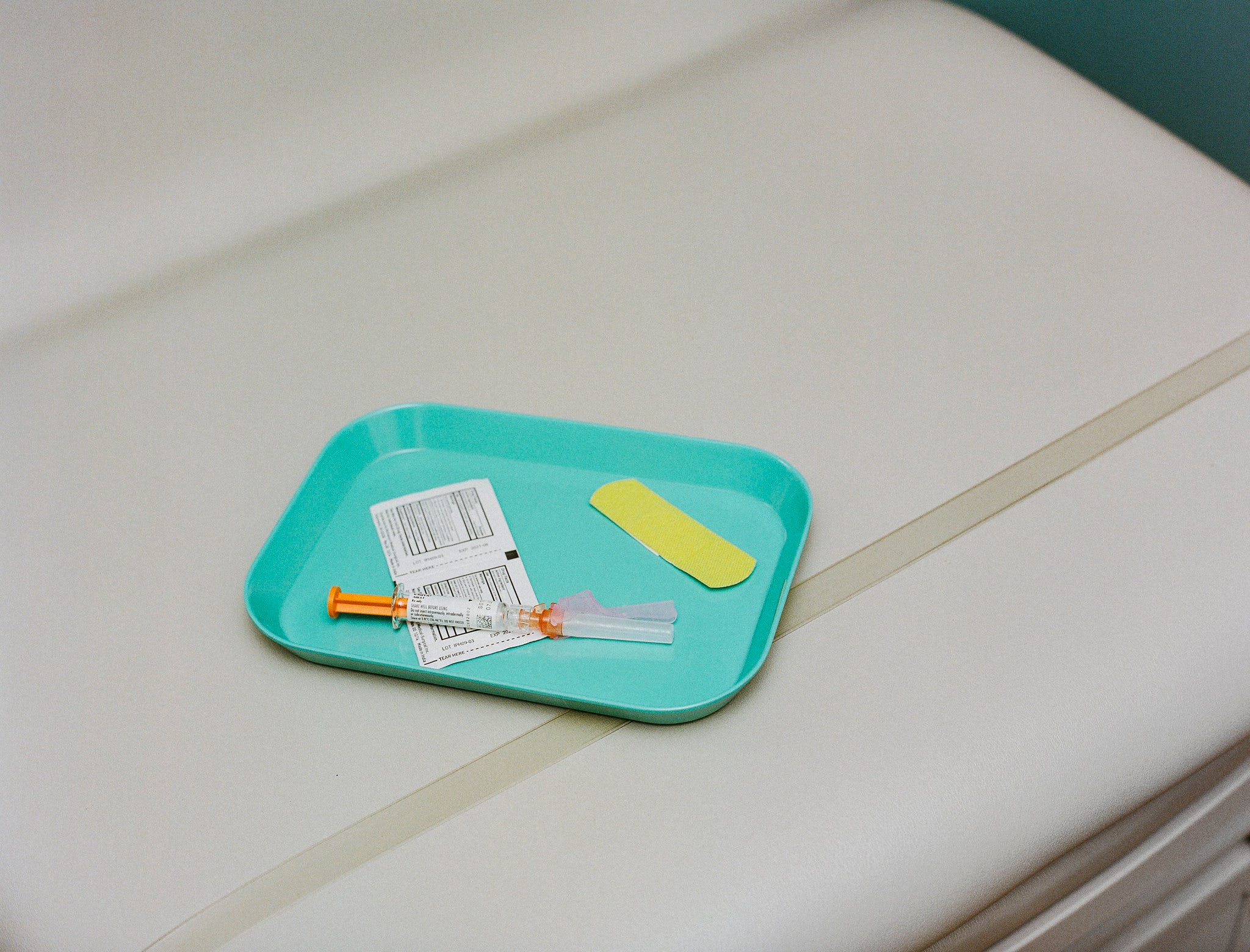 A tray with a bandaid and shot.