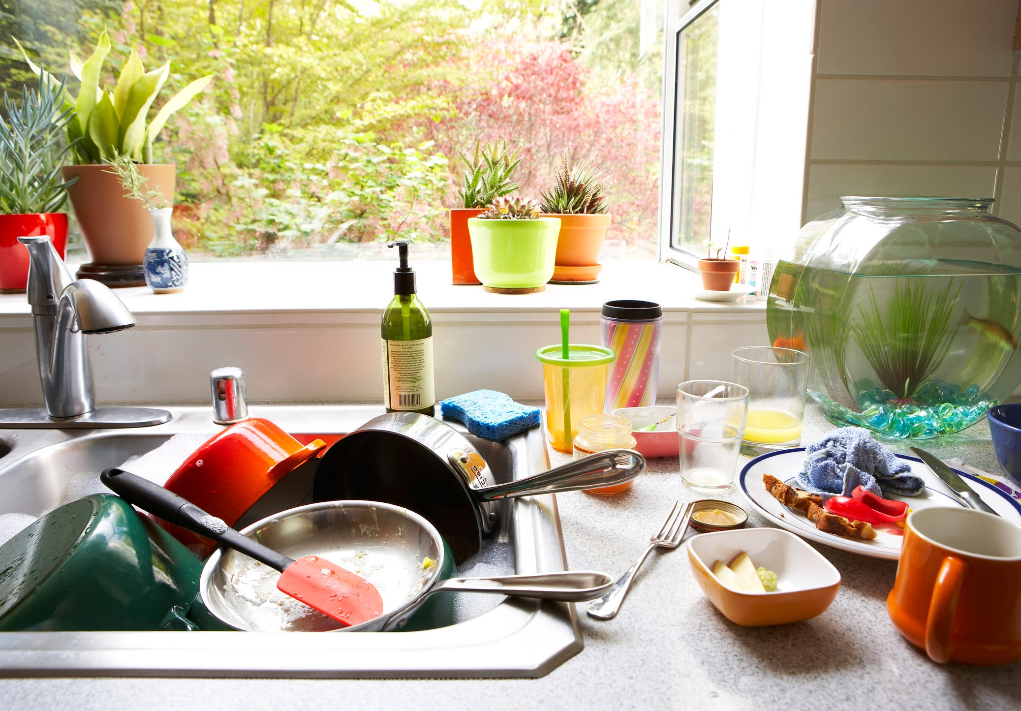 Cluttered kitchen sink with dirty dishes.