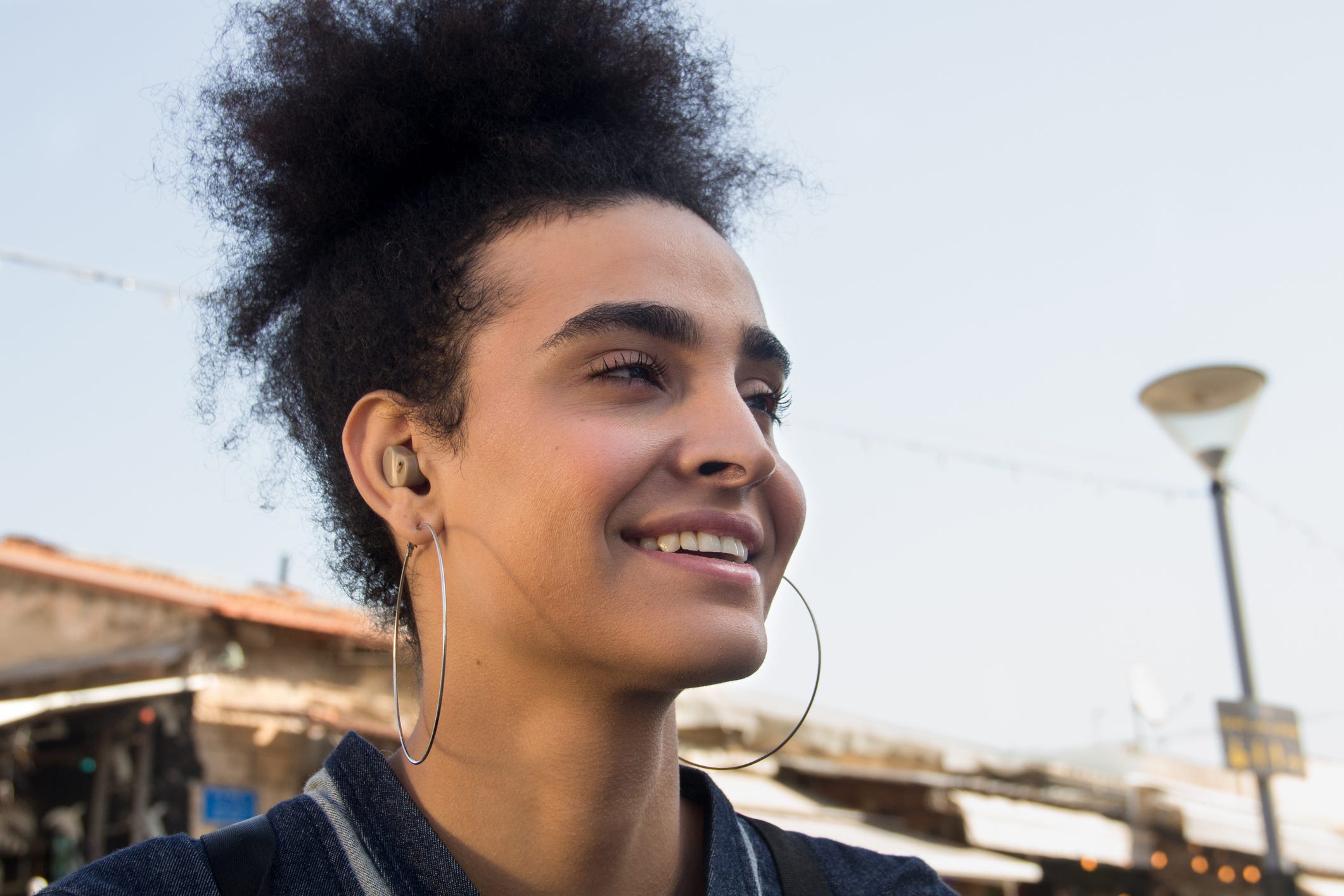 Confident young woman with hoop earrings.