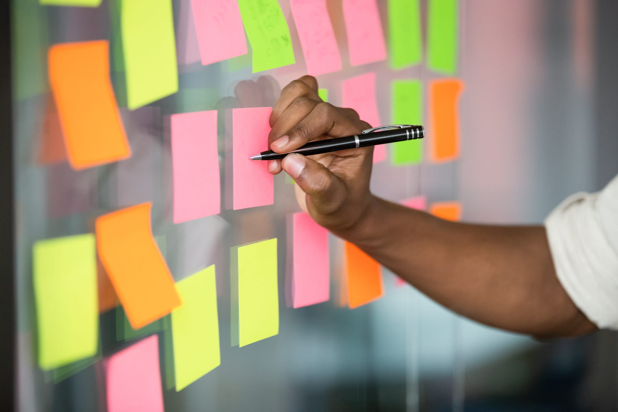 Person writing on post it.