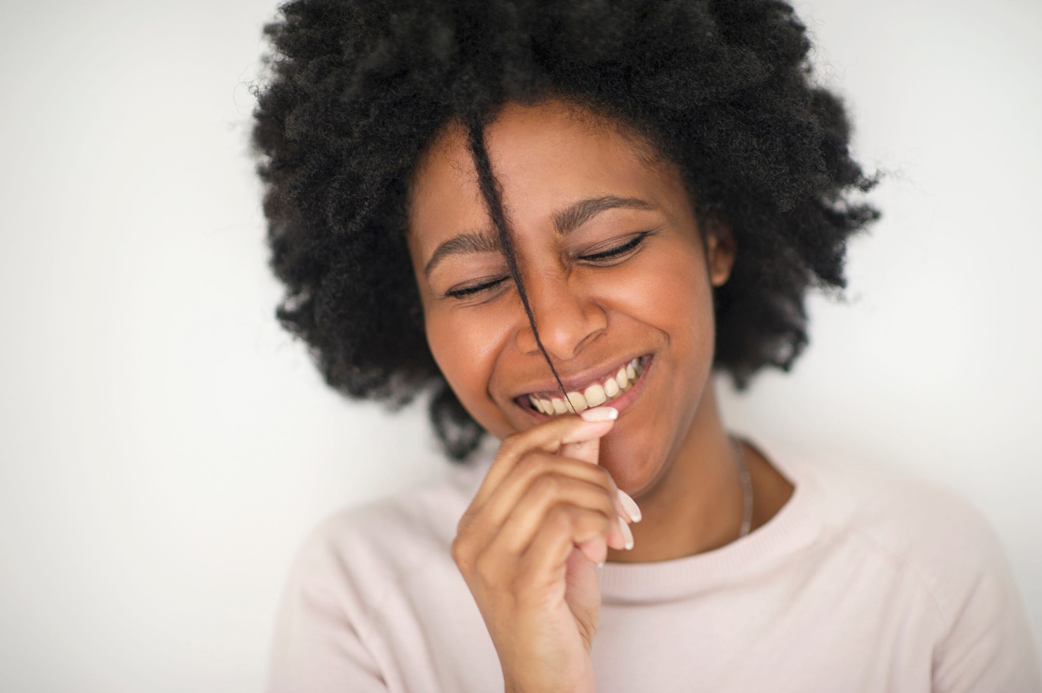 Smiling Black woman with natural hair.
