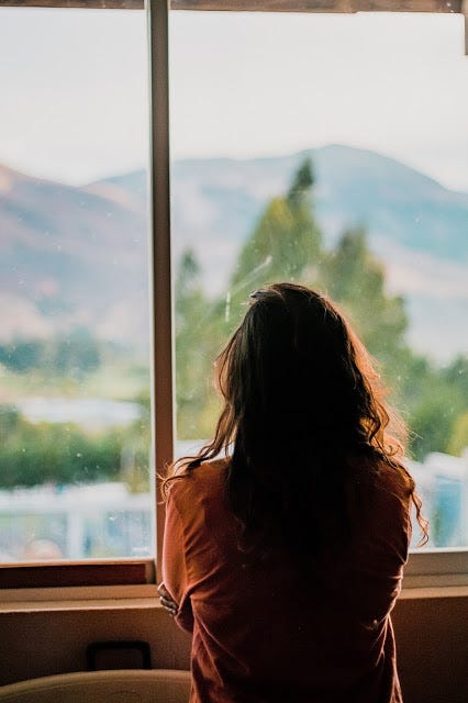 A woman standing in front of a window