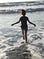 Girl running into the waves.
