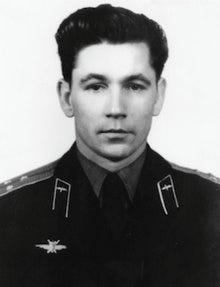 A formal portrait of a serious, dark-haired man in military uniform