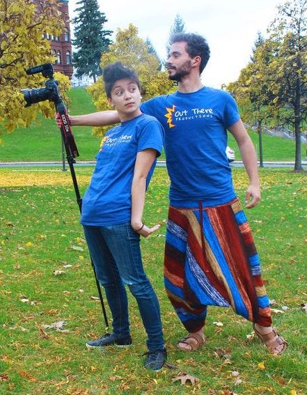 Erin posing with Johnny, wearing matching shirts, in front of Crouse College