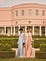 Models in pastel silk gowns in front of a courtyard