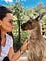girl poses with an interested kangaroo in Australia
