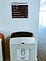 Tactile wayfinding board on wall over large waste bin