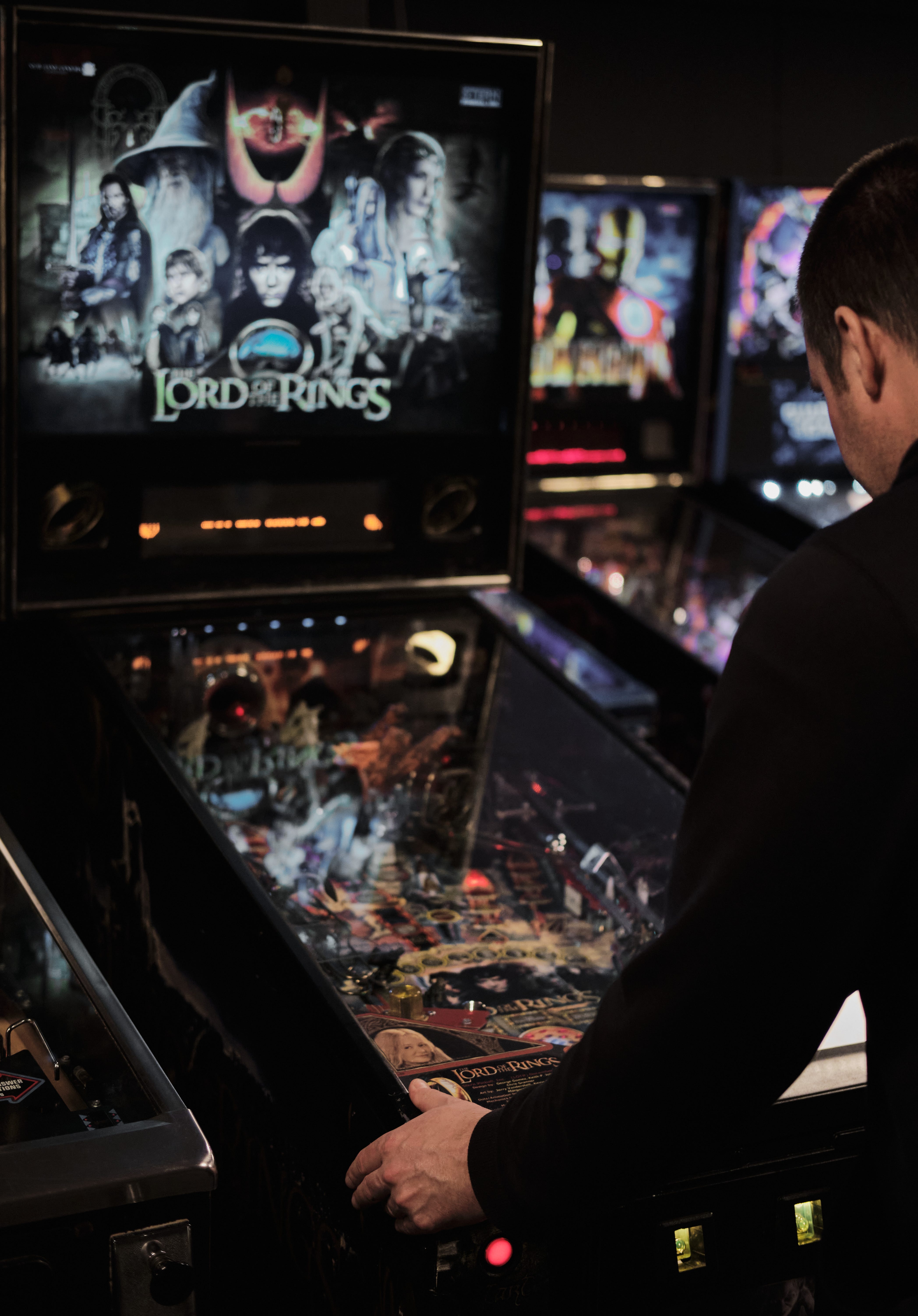 man playing a pinball machine