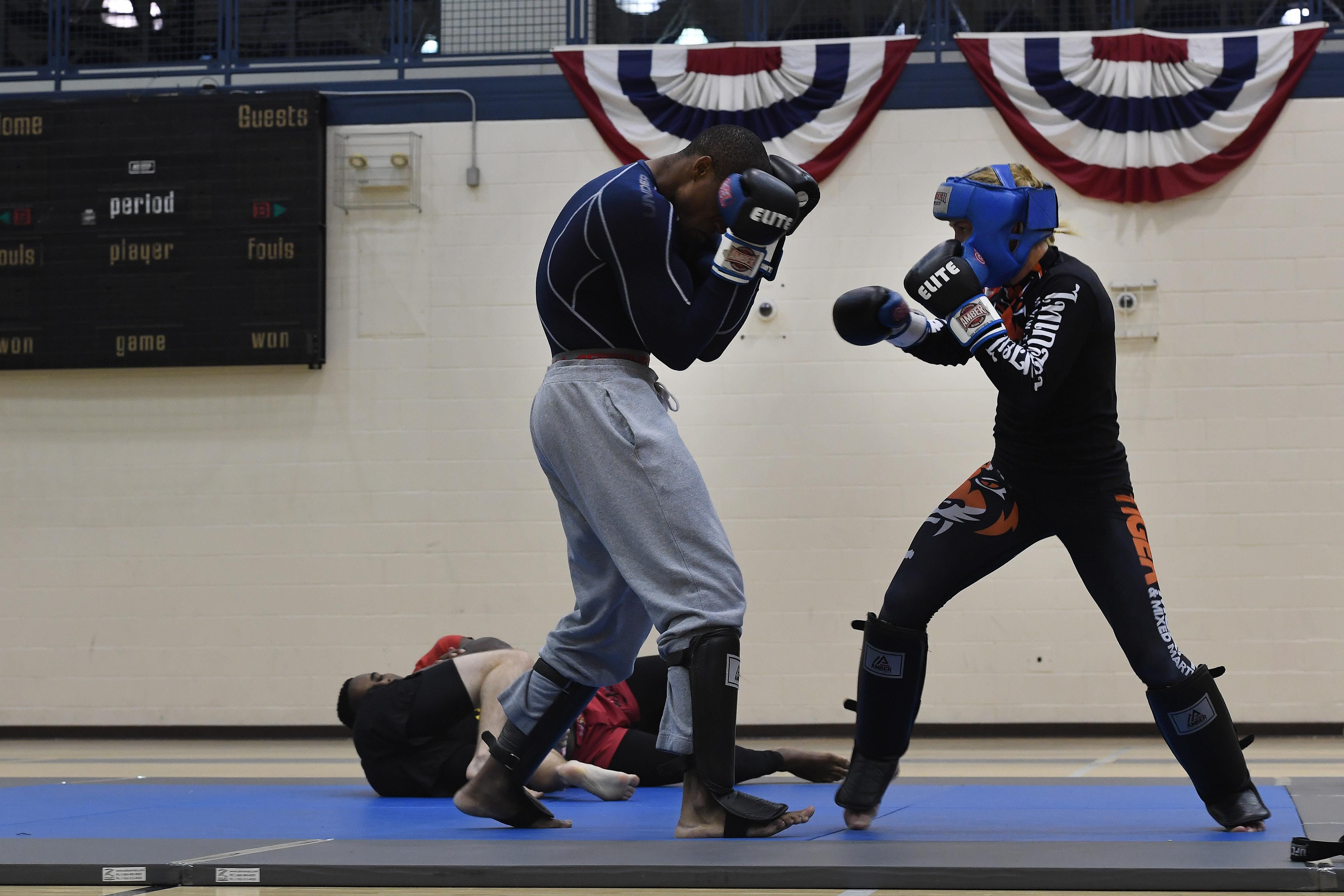 A man and woman sparring in Muay Thai
