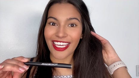 MasterGlam beauty influencer holding Amaze Brow Trio a 2-in-1 tinted brow pen + growth serum