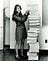 Margaret Hamilton, director of software engineering for the Apollo, standing next to a stack of paper containing Software