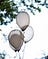 four clearish-white, oval, helium balloons outside
