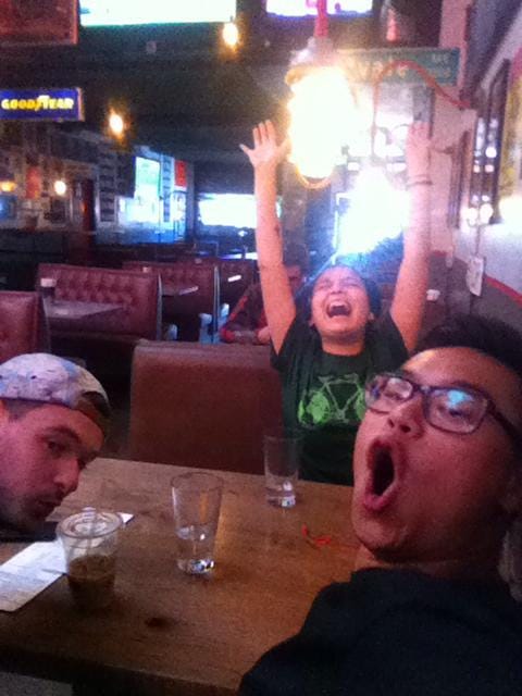 3 people sitting at a booth in a restaurant excited to eat tacos