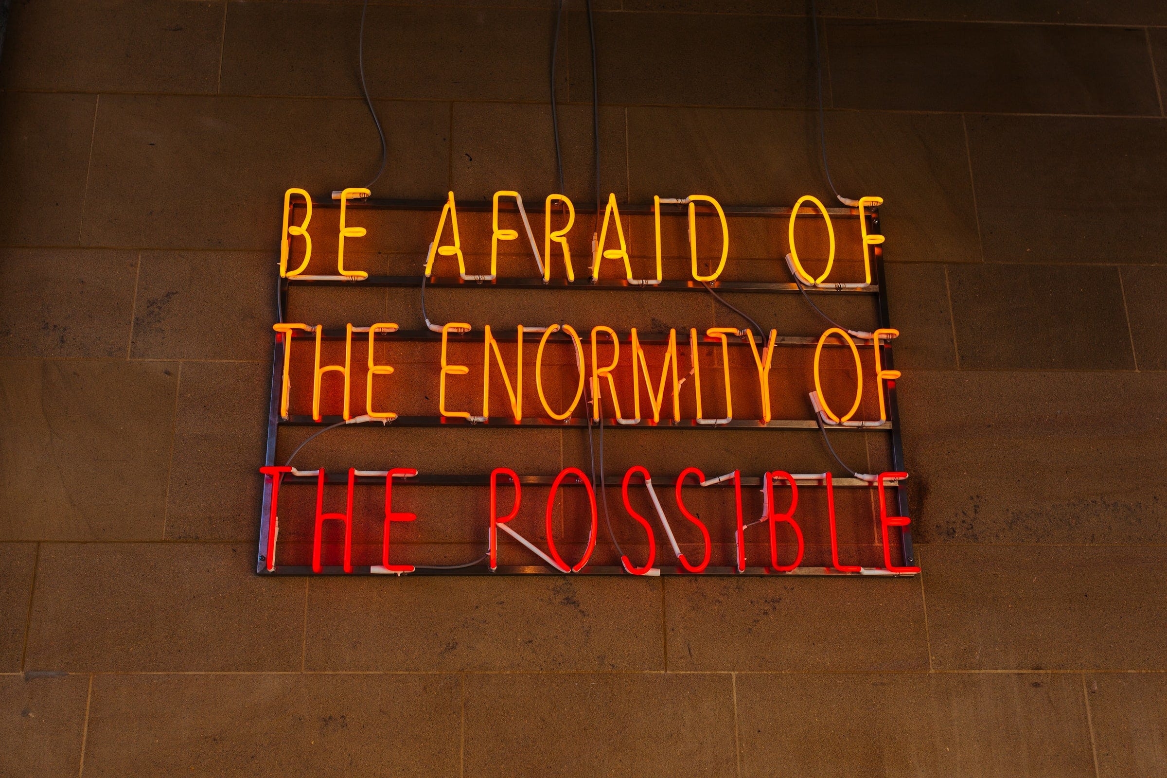 Neon sign that says, Be Afraid of the Enormity of the Possible