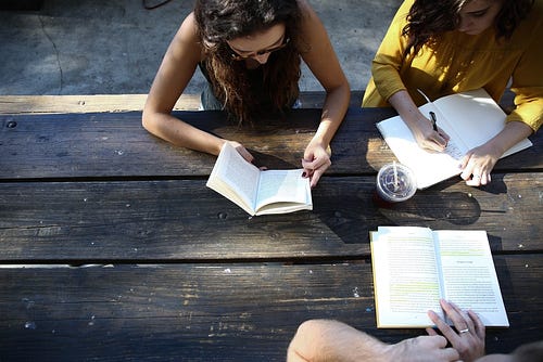 Overhead view of three people studying at a table.