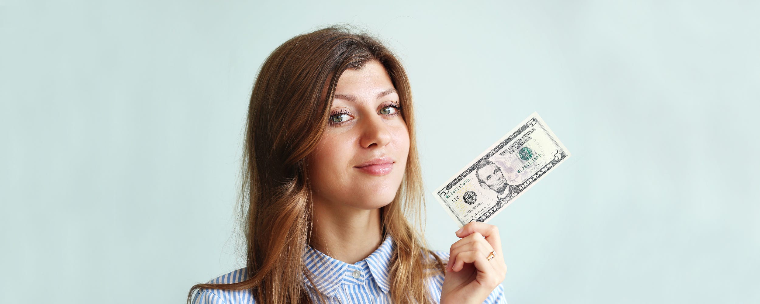 Woman holding five dollar bill