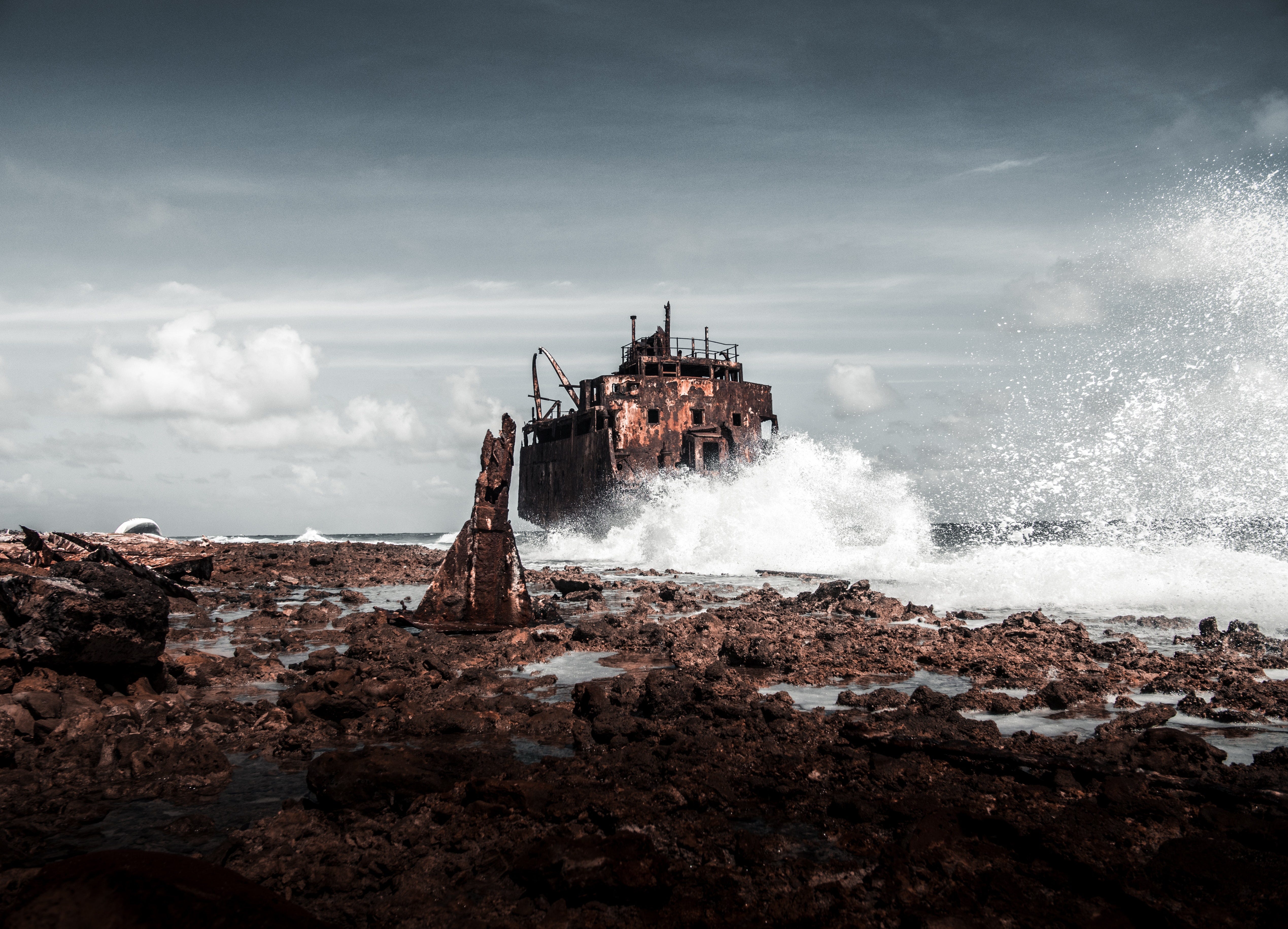 Waves crashing on rock with a derelict building in the background