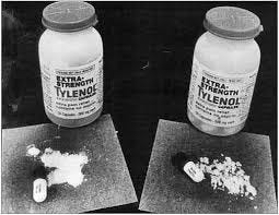 Tylenol bottles and opened pills with loose powder in front of them