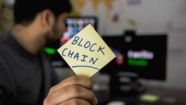 A man holding a chit with blockchain written on it