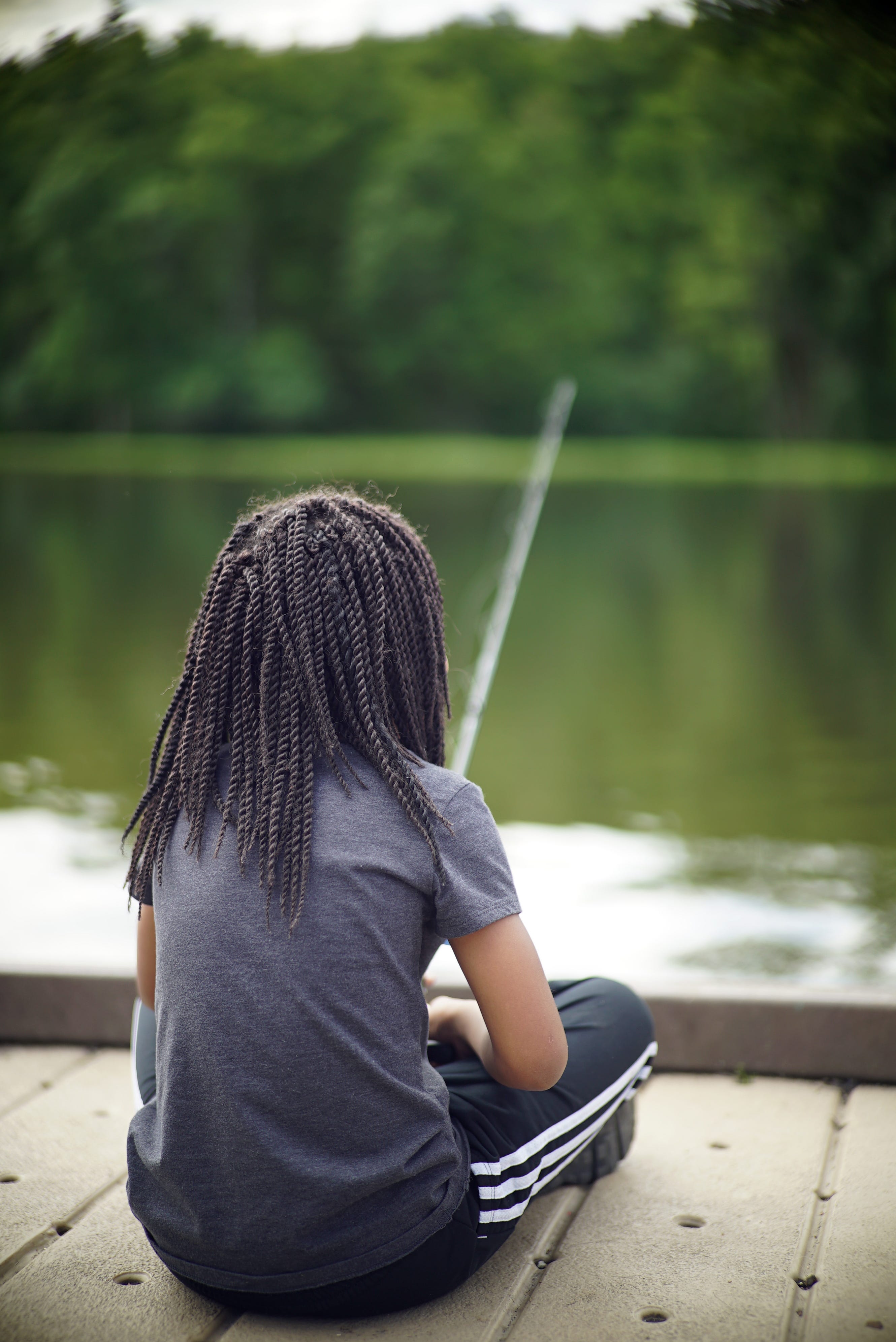 Young girl sitting on a dock fishing