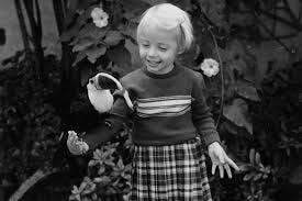 A little girl with a toucan perched on her arm