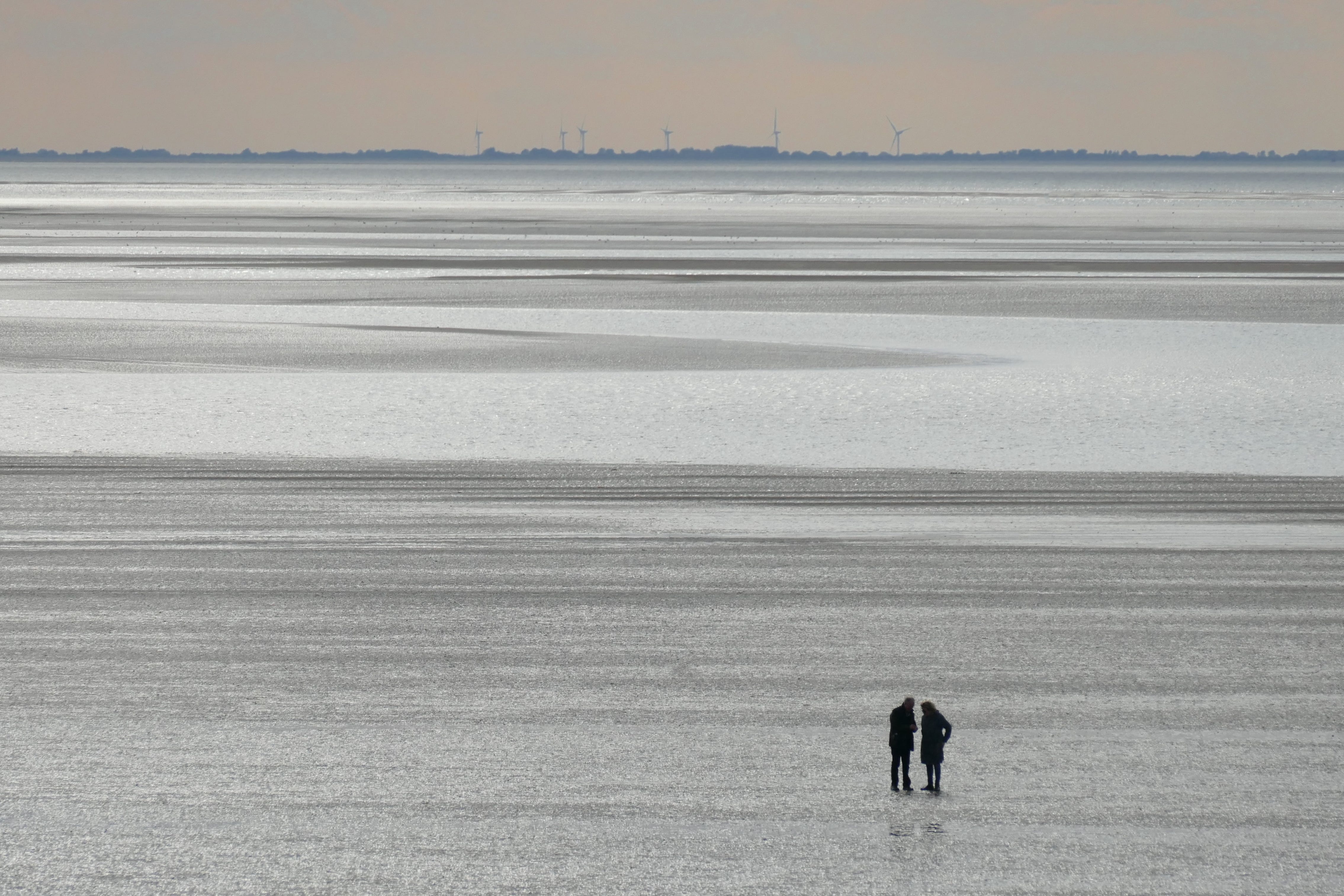 conversation between two people while standing on a beach