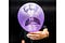 A man holds in front of himself a purple balloon with a crying face drawn on it.