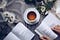 Two books beside a coffee cup on a table.
