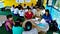 Two groups of villagers sit in the ground in circles, sharing ideas with a team of local researchers in Myanmar