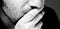 Bottom half of a man’s face with hand over mouth